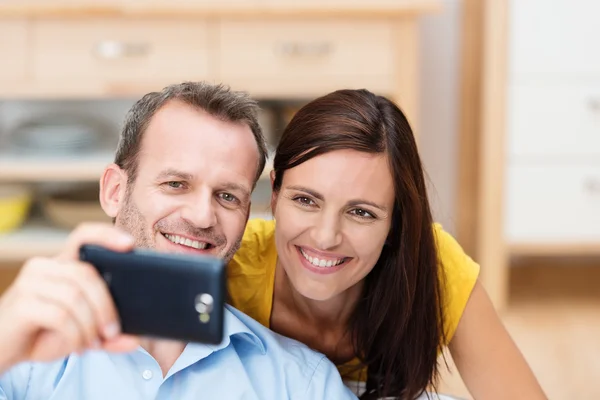 Happy couple looking at the photos on the camera — Stock Photo, Image