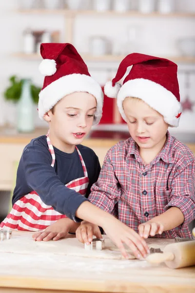 Two little brothers cutting out Christmas cookies — Stock Photo, Image