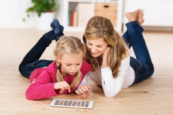 Мать и дочь играют на планшете — стоковое фото