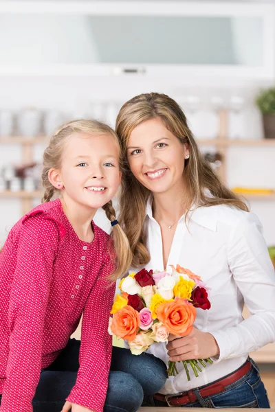Sonrientes madre e hija con un ramo de rosas — Foto de Stock