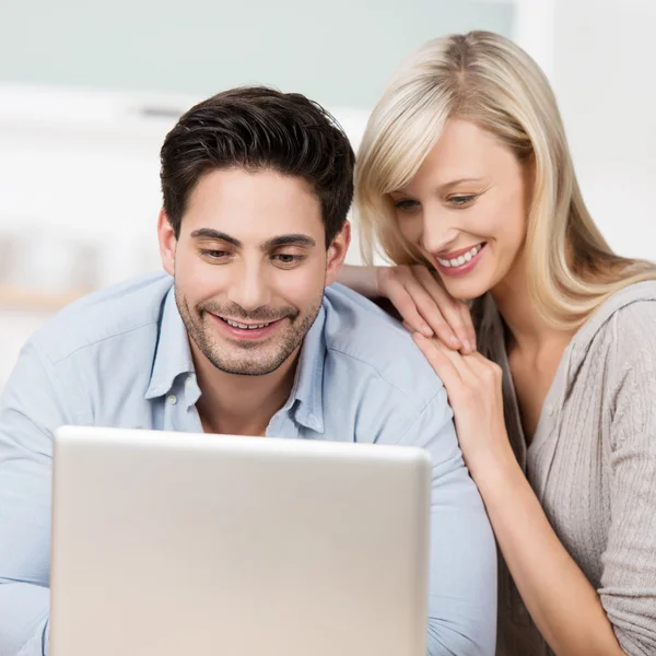 Uomo al lavoro sul suo computer portatile guardato da sua moglie — Foto Stock