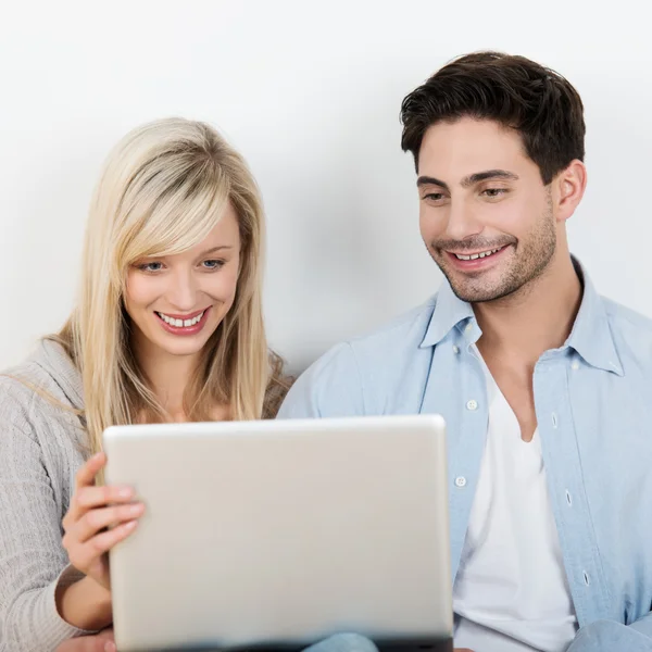 Pareja leyendo información sobre un ordenador portátil — Foto de Stock