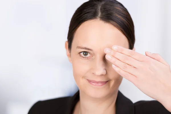 Vrouw die een oog bedekt met haar hand — Stockfoto