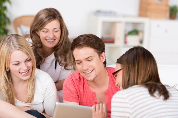 Groep van jonge studenten kijken naar een tablet — Stockfoto