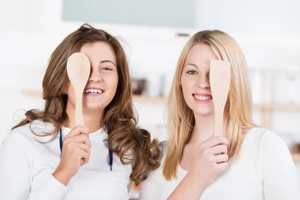 Two playful teenage girls with kitchen utensils — Stock Photo, Image