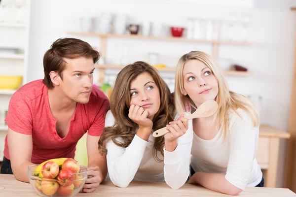 Trois jeunes amis indécis sur quoi cuisiner — Photo