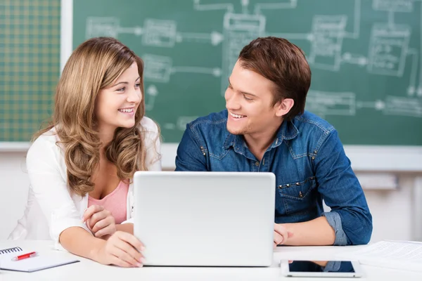 Två tonåriga elever delar en laptop i klass — Stockfoto