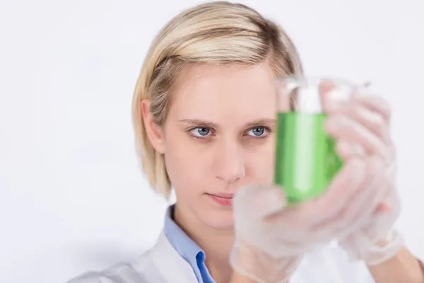 Женщина в лаборатории изучает химический раствор — стоковое фото