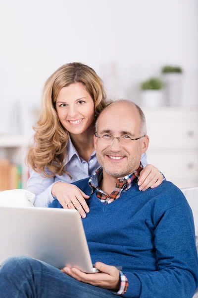 Sonriente pareja cariñosa utilizando un ordenador portátil — Foto de Stock