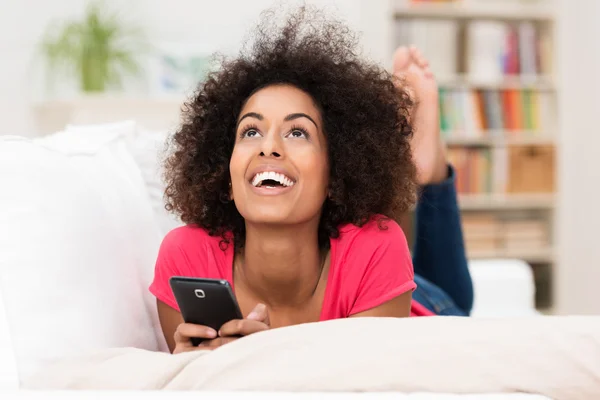 Mujer feliz pensando en un mensaje de texto — Foto de Stock