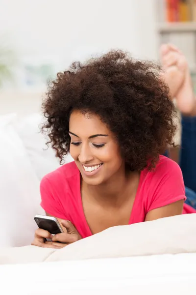 Lächelnde Frau liest SMS auf ihrem Handy — Stockfoto