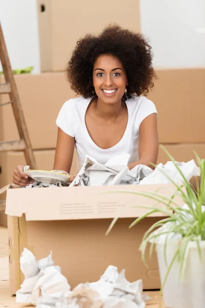 Happy woman unpacking a cardboard carton — Stock Photo, Image