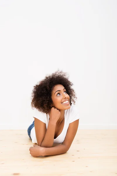 Mujer joven feliz tendida en el suelo soñando despierto — Foto de Stock