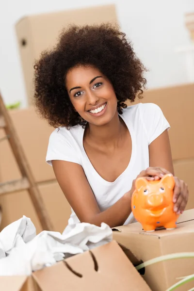 Smiling young woman caressing her piggy bank — Stock Photo, Image