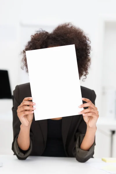 Empresária escondida atrás de uma folha de papel em branco — Fotografia de Stock