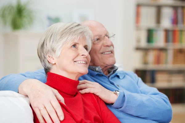 Glückliches älteres Paar sitzt und schaut etwas zu — Stockfoto