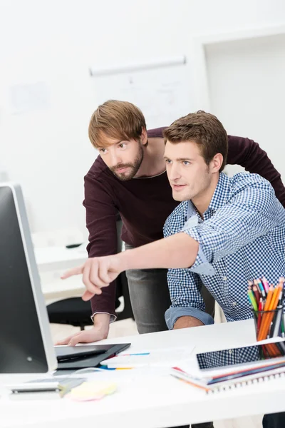 Empresário apontando para seu monitor de computador — Fotografia de Stock