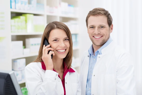 Farmacista sorridente che chiacchiera al telefono — Foto Stock