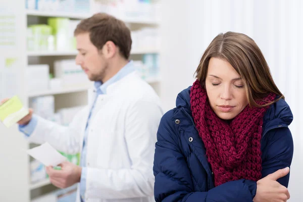 Больная женщина ждет в аптеке — стоковое фото