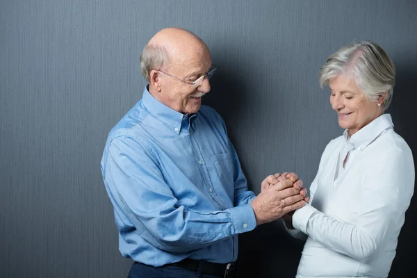 Devoted senior couple holding hands — Stock Photo, Image