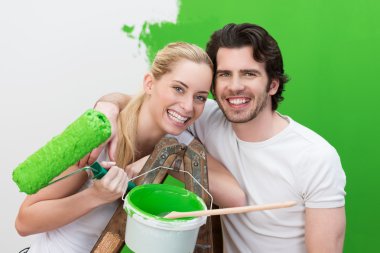 Couple painting their house green clipart