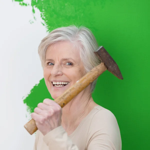 Смеющаяся пожилая женщина, украшающая интерьер — стоковое фото