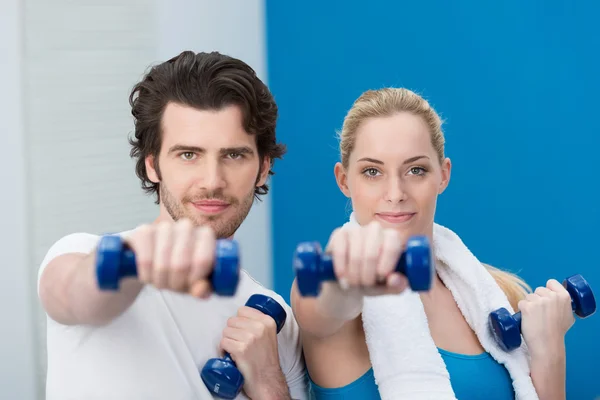 Ajuste pareja joven haciendo ejercicio en el gimnasio — Foto de Stock