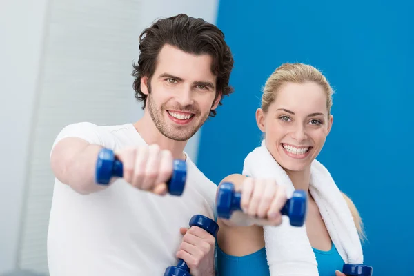 Motivated young couple working out with dumbbells — Stock Photo, Image