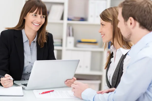 Young couple talking to a woman broker — Stock Photo, Image