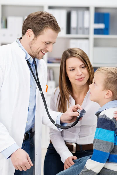 Молодой врач осматривает маленького мальчика — стоковое фото