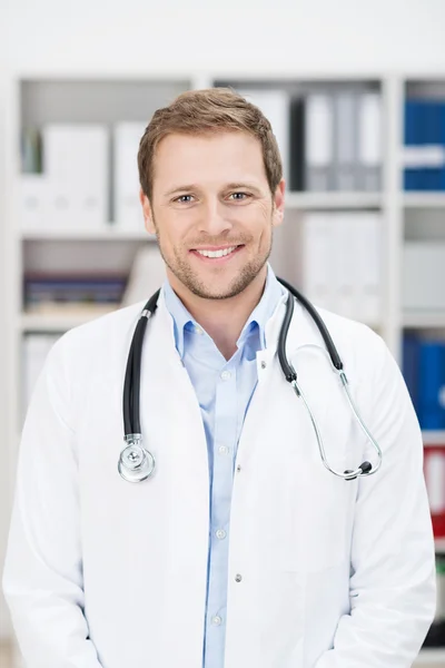 Handsome smiling doctor in his office — Stock Photo, Image