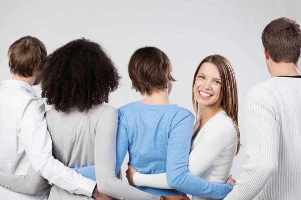 Grupp vänner länka vapen vänd bort — Stockfoto