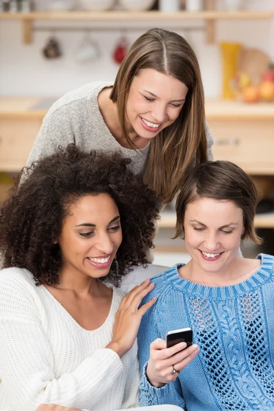 Three beautiful women reading a text message — Stok fotoğraf