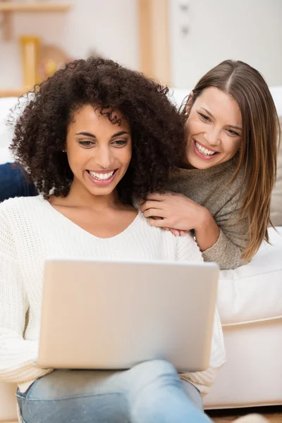 Duas mulheres relaxando em casa com um laptop — Fotografia de Stock