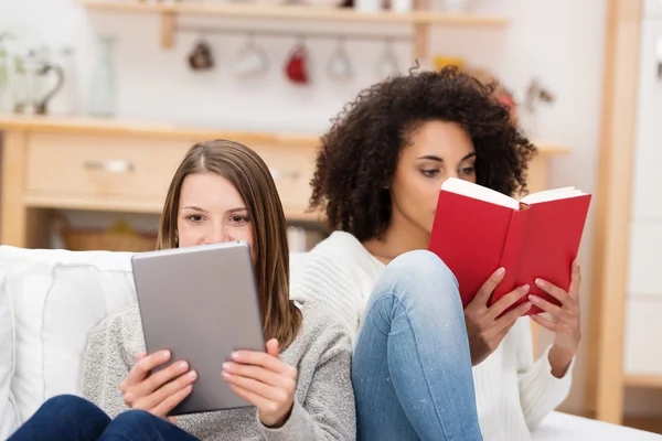 Dos mujeres jóvenes relajándose juntas leyendo — Foto de Stock