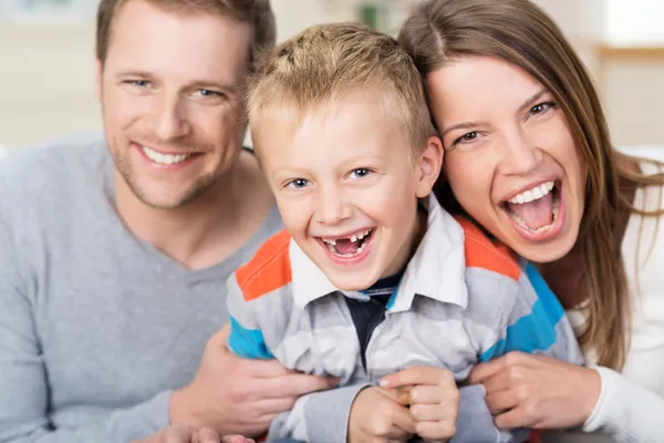 Ein lachender kleiner Junge mit seinen jungen Eltern — Stockfoto