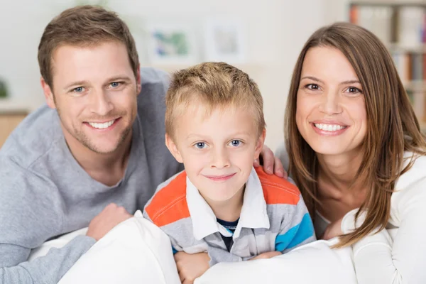 Felice bambino con i suoi giovani genitori sorridenti — Foto Stock