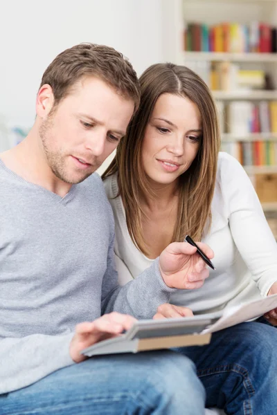 Young couple sitting checking their finances — Stock Photo, Image