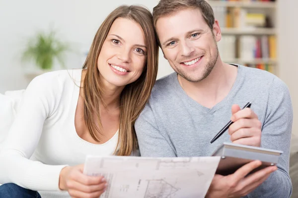 Happy young couple looking at a diagram — Stock Photo, Image