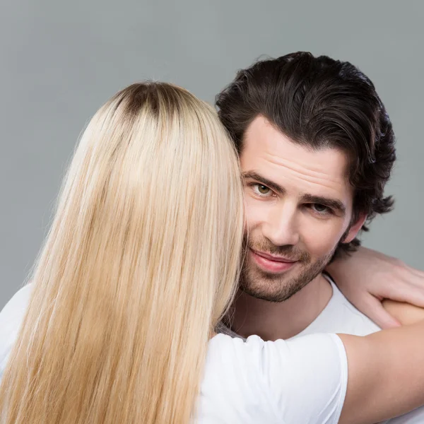 Man smiling as he is hugged by his wife — Stock Photo, Image
