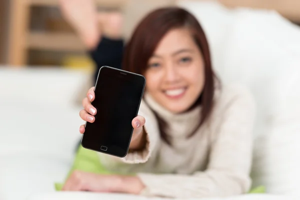 Young woman holding up her mobile phone — Stock Photo, Image