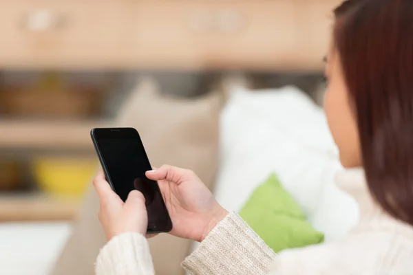 Jovem mulher mensagens de texto em seu smartphone — Fotografia de Stock