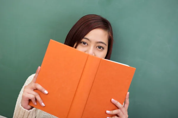 Studentin schaut über ihr Buch — Stockfoto