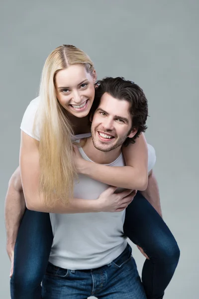 Man giving piggy back ride to girlfriend — Stock Photo, Image