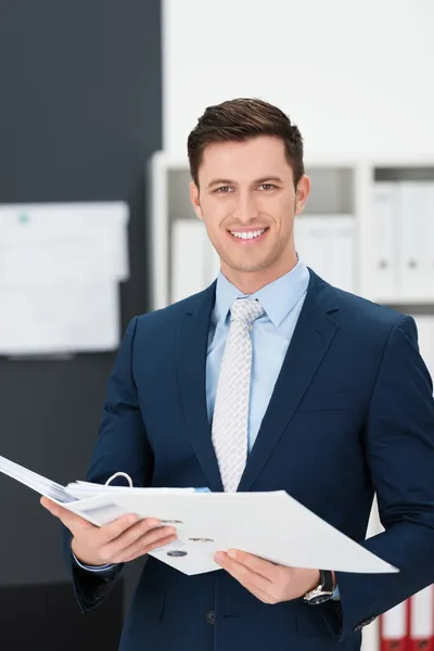 Stijlvolle jonge zakenman houden van een bestand — Stockfoto