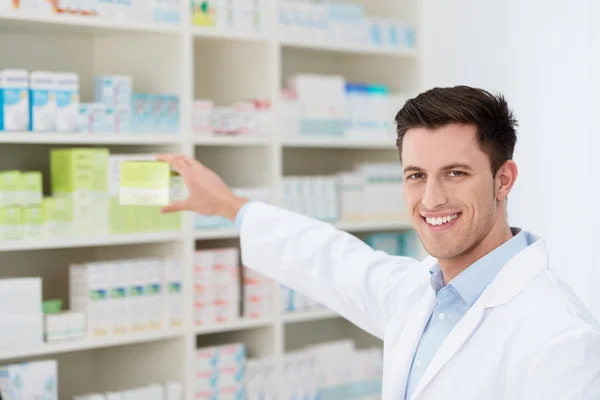 Smiling pharmacist promoting a product — Stock Photo, Image