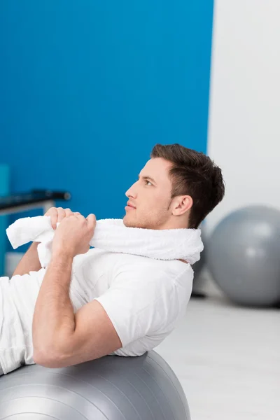 Joven haciendo ejercicio usando una pelota de gimnasio —  Fotos de Stock