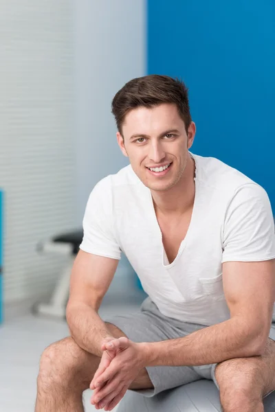 Athletic young man sitting on a pilates ball — Stock Photo, Image