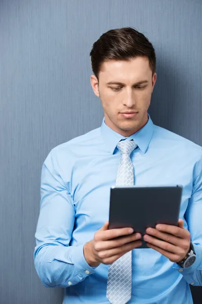 Empresário lendo informações em seu tablet — Fotografia de Stock