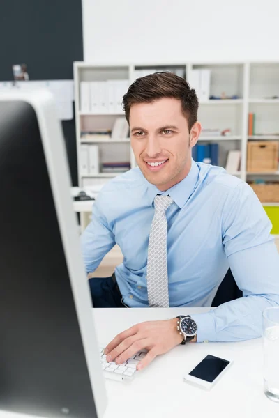 Empresário trabalhando em um computador desktop — Fotografia de Stock